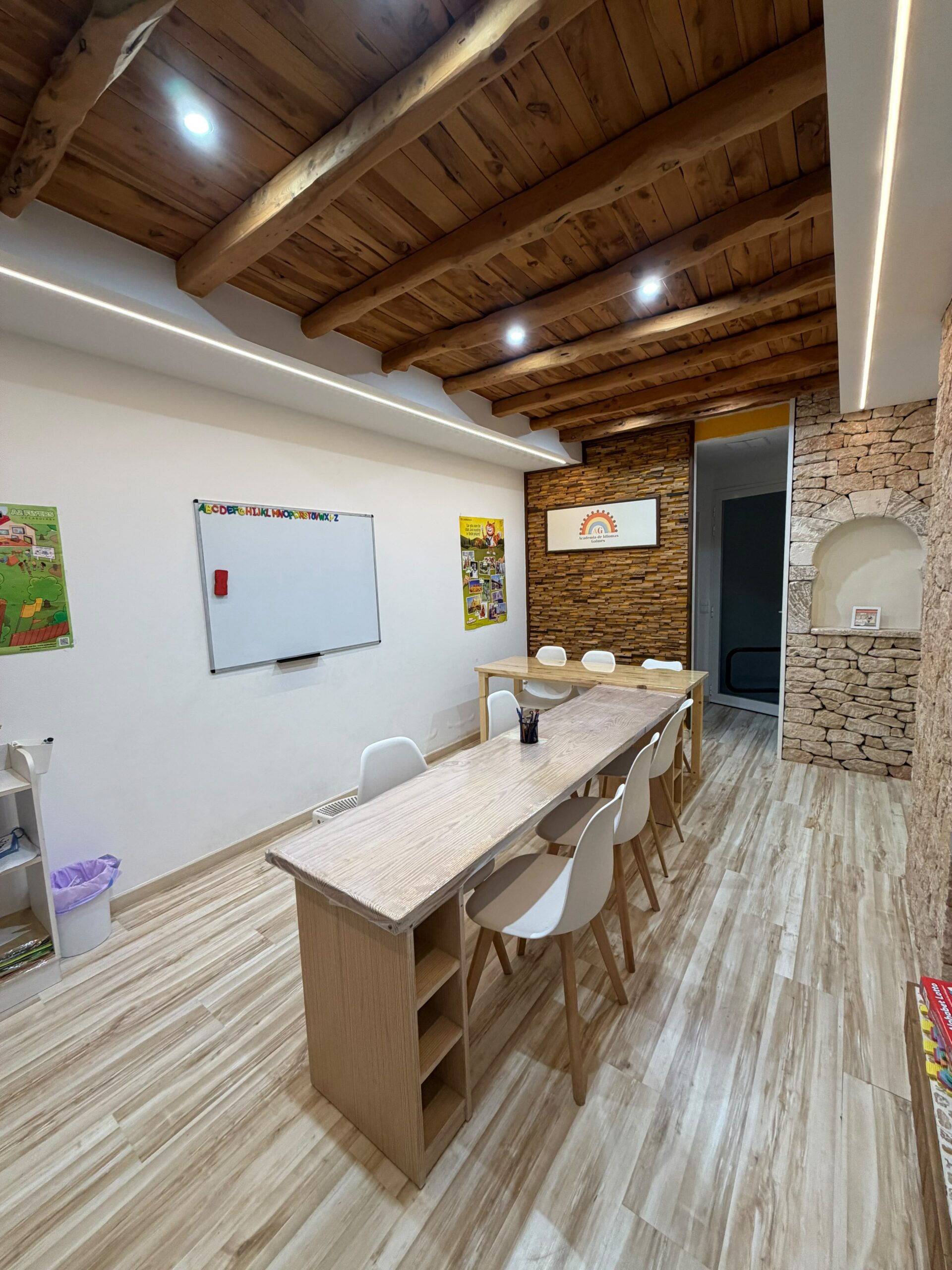Aula de la academia con pizarra y vigas de madera